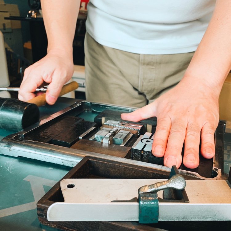 活字を組む中野さん。仕上げにトンカチでトントンと枠をたたく。