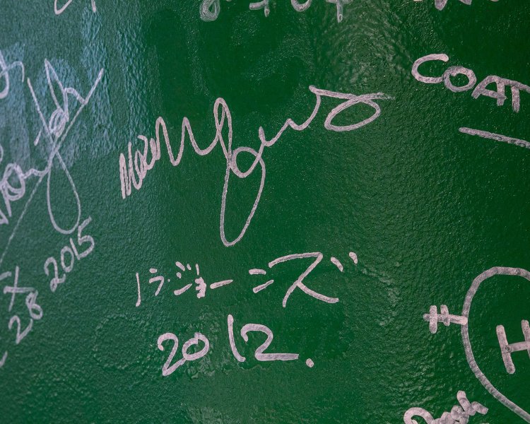 レジ横の柱に書かれた有名人のサイン（ノラ・ジョーンズの名前が）。