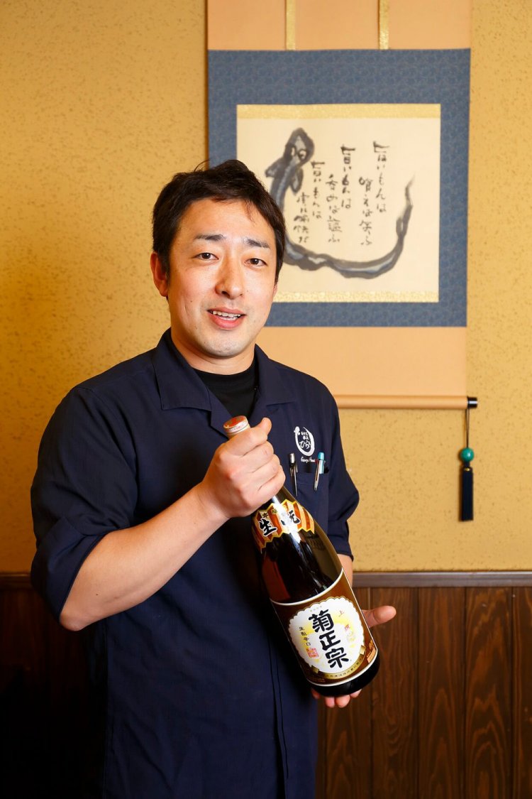 平井さんが手にするのは菊正宗生酛。「これが骨酒に合うんです」。
