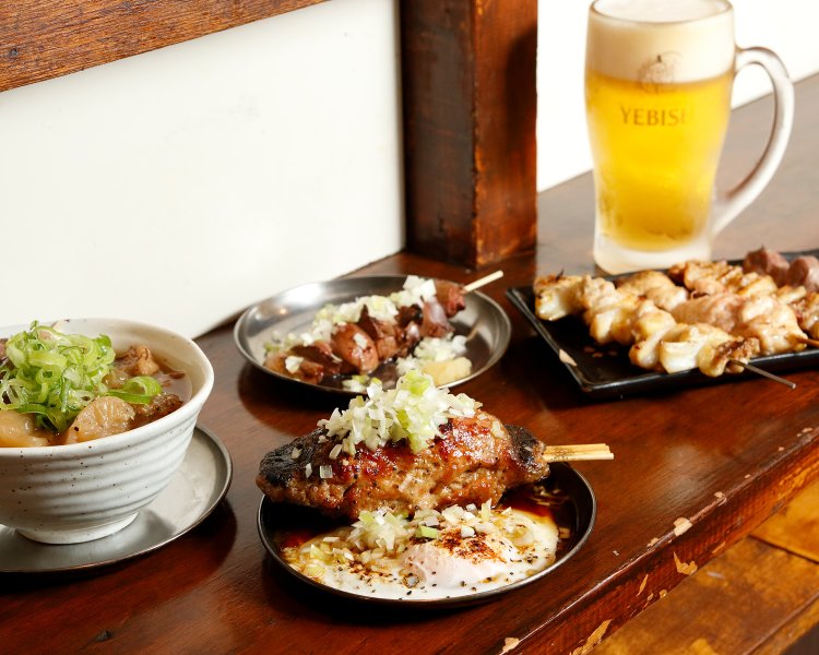 赤提灯の光と炭焼きの煙に誘われた客でにぎわう。