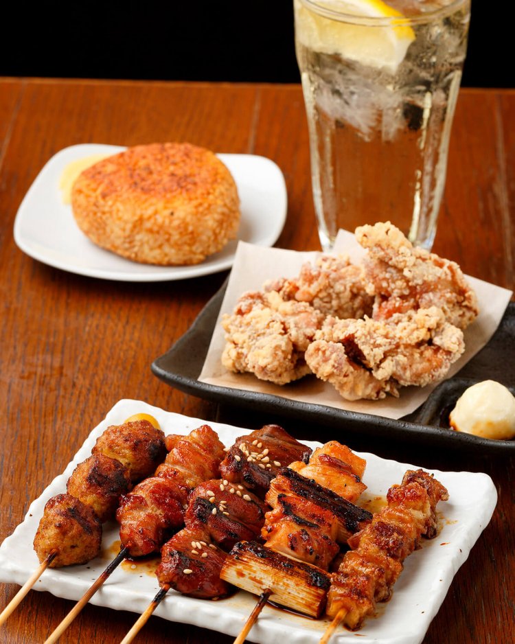 手前から焼き鳥５本盛り750円、鳥のから揚げ650円。新潟県産コシヒカリを使った焼きおにぎり300円は、締めの一番人気。ハイボール450円。