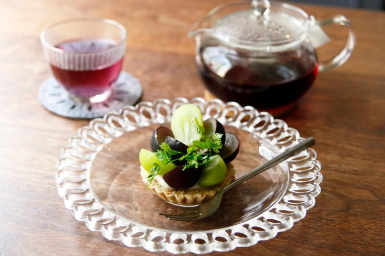 ノンカフェインの黒人参茶500円、季節のロータルト700円は宝石のごとく旬で彩りを変える。写真はブドウ。秋冬は柿、リンゴ、イチゴなど。