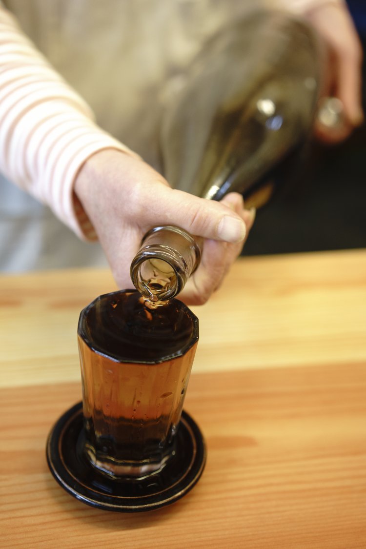 毎日仕込む特製の焼酎、梅割220円は、一升瓶でグラスいっぱいに注いでくれる。一升瓶が７本も空く日もあるほど人気。