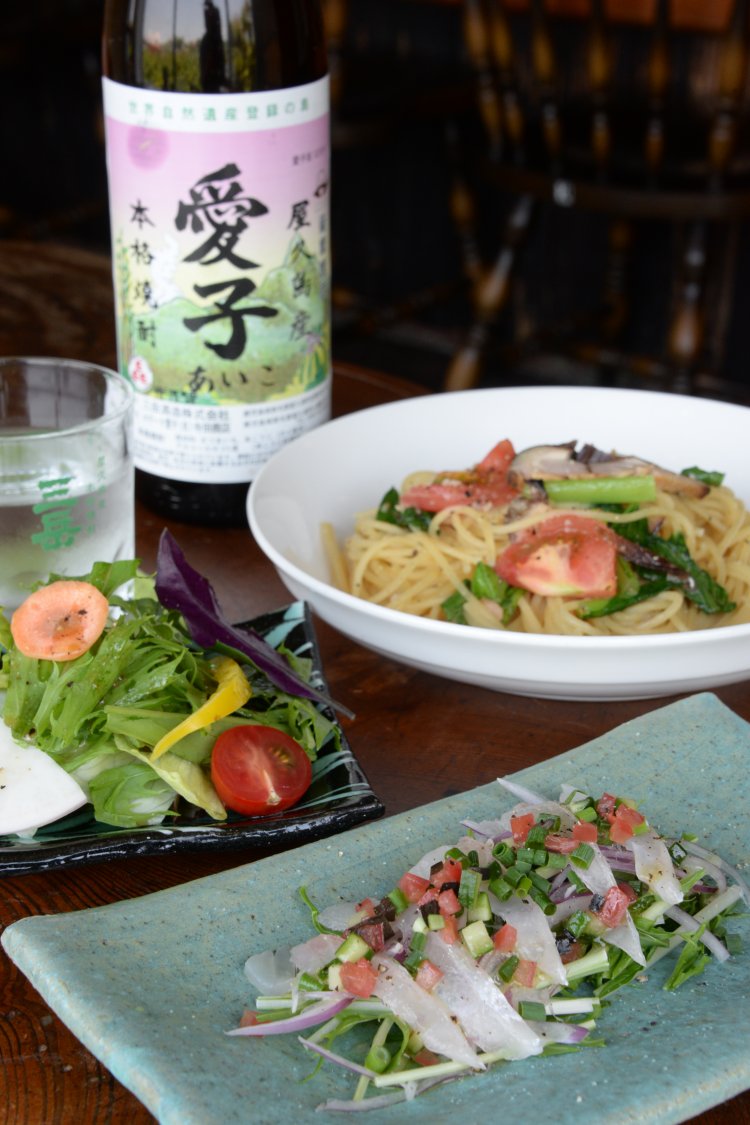飛魚マリネと香味野菜のサラダ仕立て６５０円。季節のスパゲッティ８５０円〜。焼酎の種類も多い。