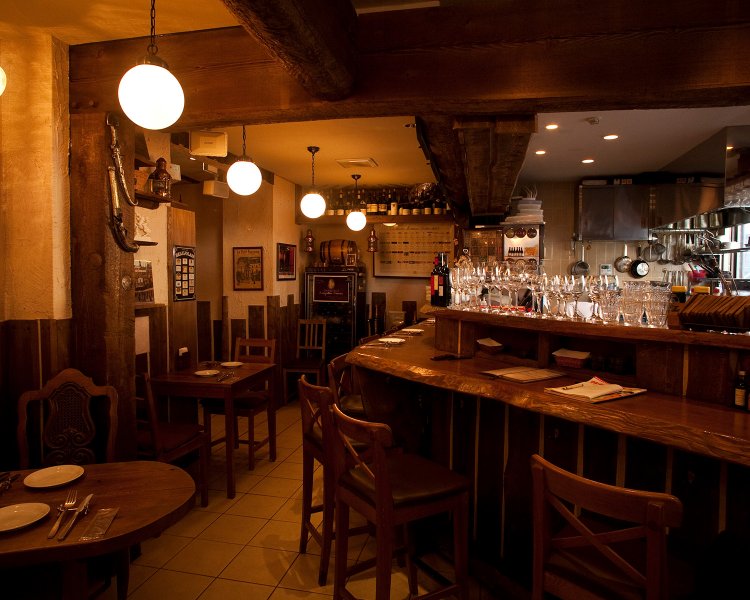 キッチンを囲むカウンター席、奥まったテーブル席。シェフは全席を見渡せる。