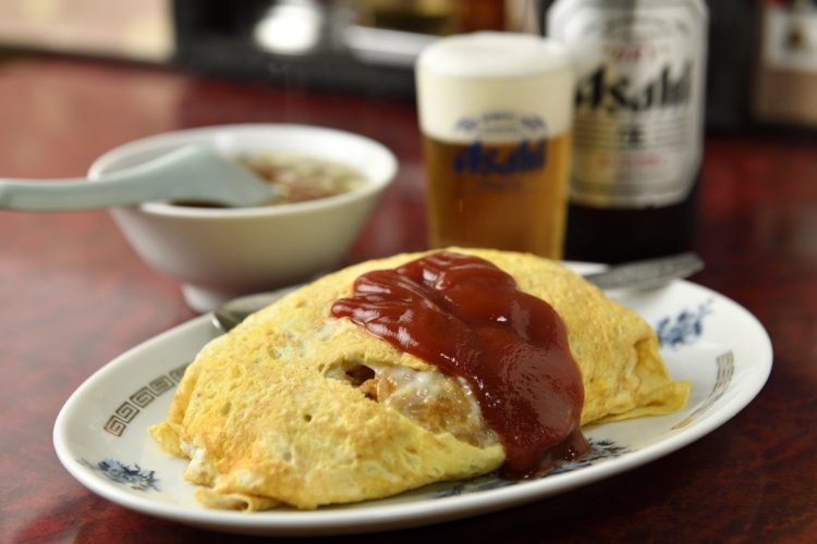 オムライス800円はバターたっぷりで風味絶佳。ビール550円と合わせ至福のランチ。