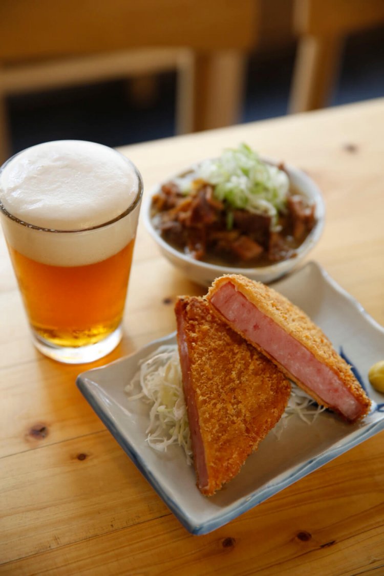 ハムカツ380円（税抜）、煮込み350円（税抜）は写真の白の他、ピリ辛の赤も用意。日替わりクラフトビール500円（税抜）。