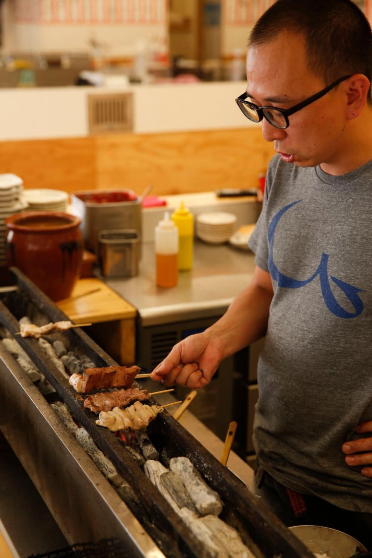 炭の火力で、モツを焼く店主。