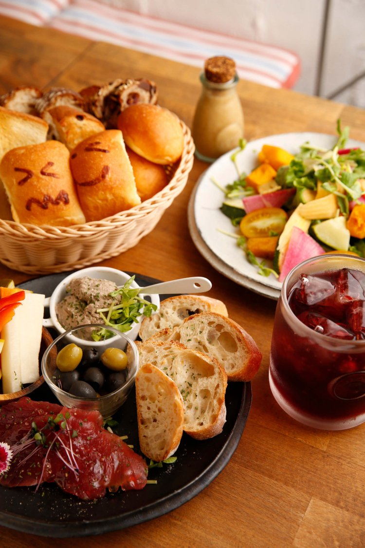 ピンチョスの盛り合わせ単品350円（3種1000円）。写真は鶏肉パテ、オリーブ、鶏ハムなど。八ヶ岳直送！ 有機野菜盛りサラダ820円、がぶ飲みワイン500円。