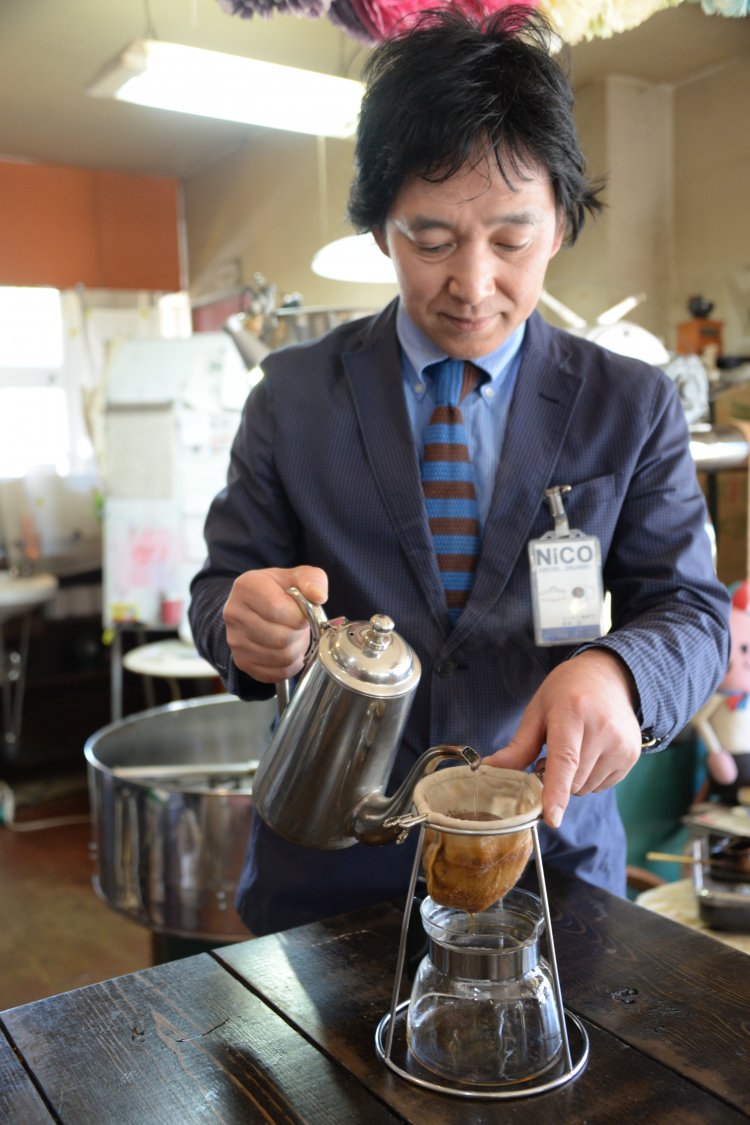 ネルドリップで丁寧に淹れる店主の松本正さん。後ろは焙煎機。