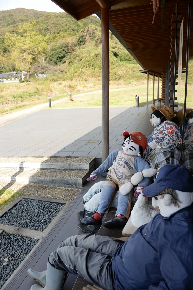 無料の休憩館は畳敷き。縁側に等身大の人形が小町山を向いて並ぶ。