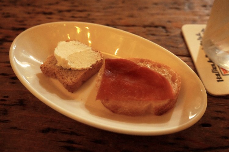 お通しはバゲットに乗ったチーズと生ハム