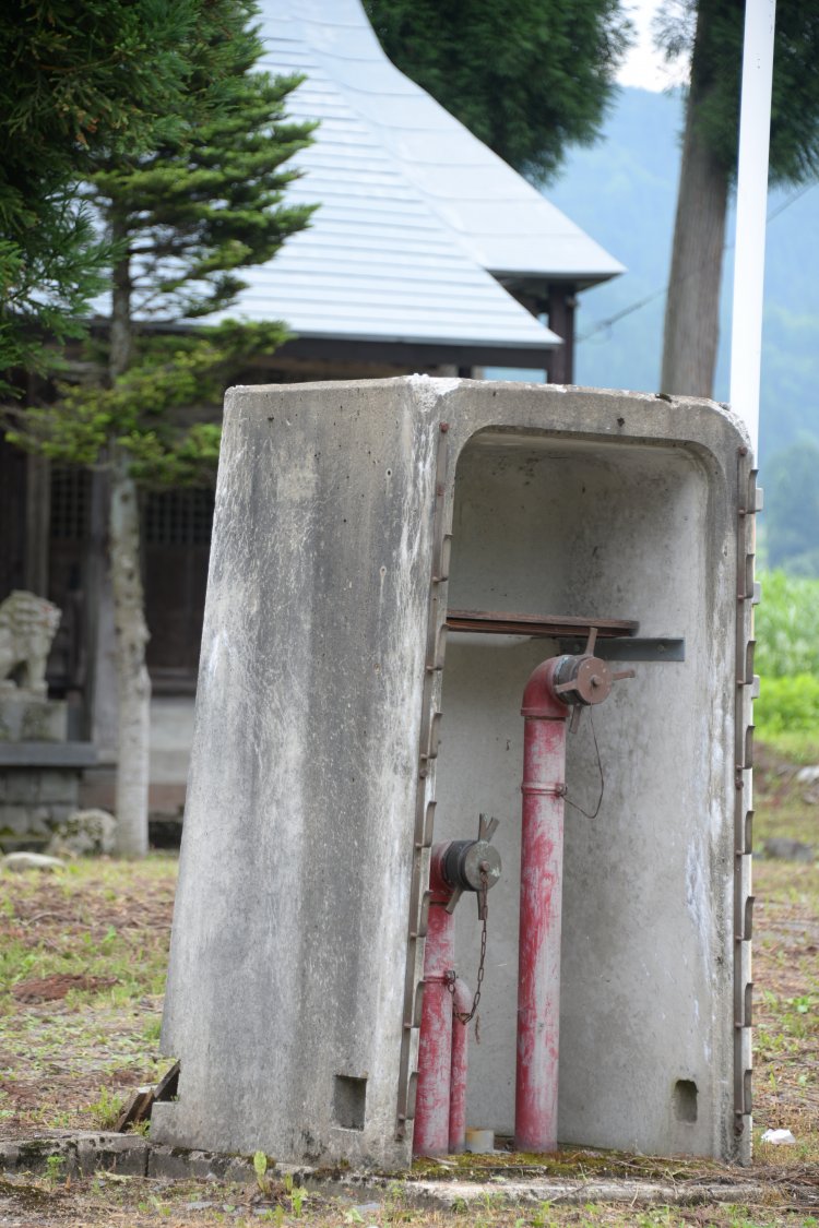 コンクリートの頑丈な雪囲いが守る消火栓。冬はさらに板で覆う。