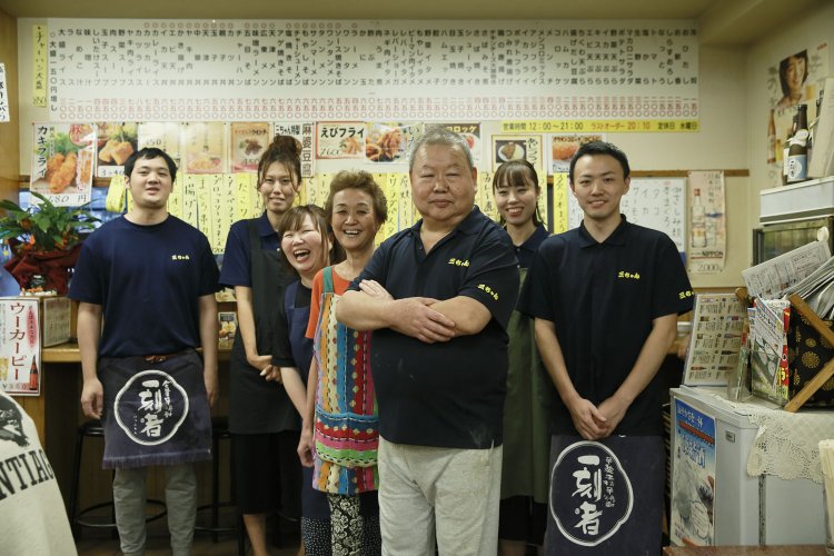 中山さん一家で切り盛り。中央の2代目女将の人柄に引かれる酔客も多い。お米は3代目のお嫁さんの弘前にある実家から送られる、あきたこまちを使用。「壁のメニューは増え続けて約150種に！」。