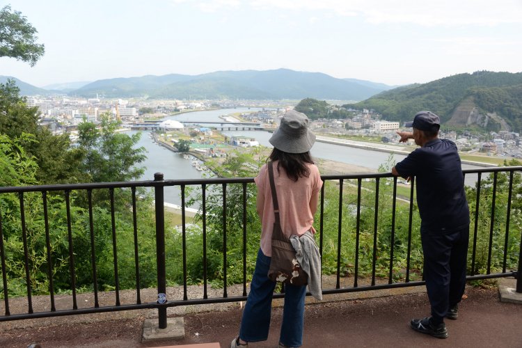 震災当時を語る散歩中の住民と、中州の「石ノ森萬画館」を眺める。