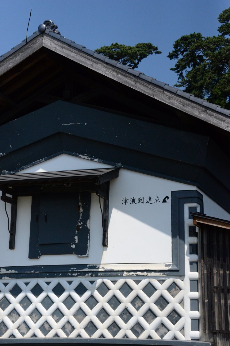 津波到達点の印がある本間家土蔵。被災後に修復、資料館になった。