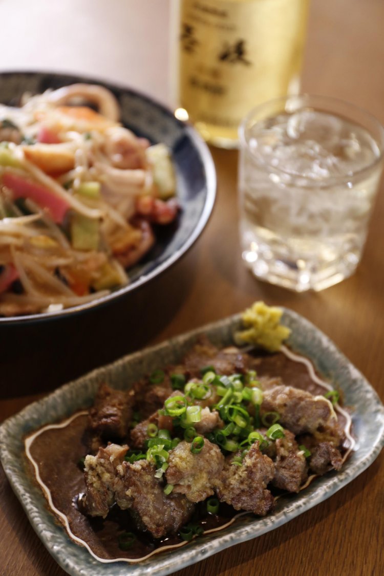 人気の牛すじニンニク炒め380円は酒が進む。皿うどん840円、長崎の焼酎「壱岐」は1杯500円。