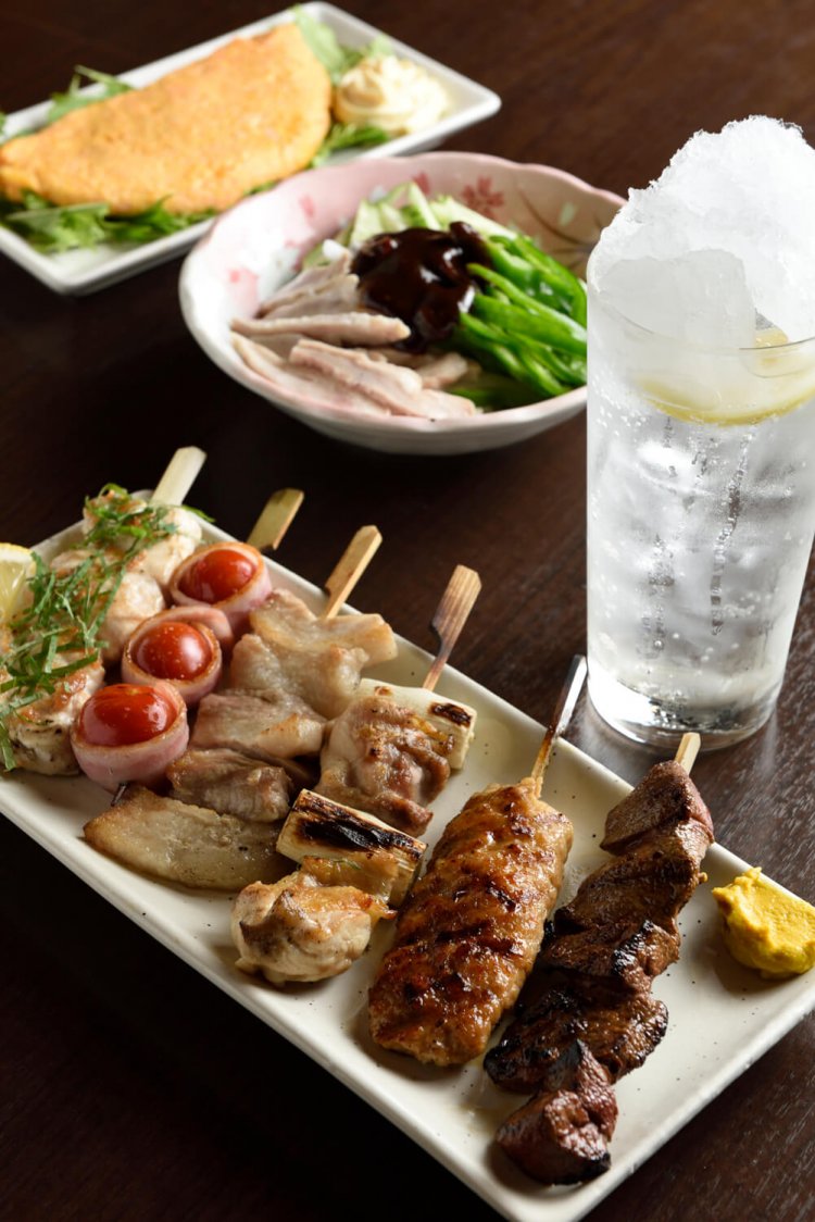 手前から豚レバ、つくね、ねぎまほか人気焼き鳥6点盛り1105円、ガツとネギ味噌463円、明太チーズオムレツ617円。シャリキンの炭酸割り390円。