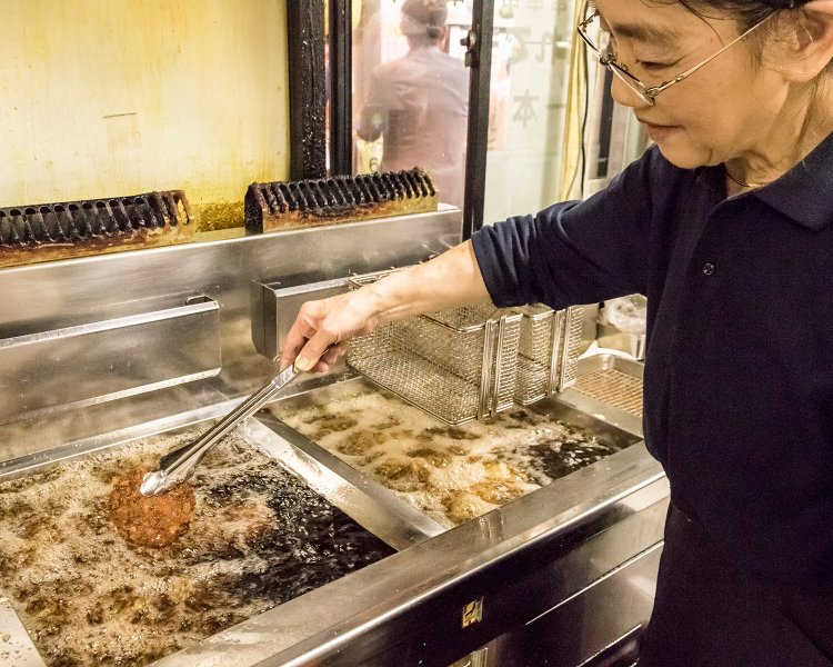 揚げる手つきが鮮やかなベテランの佐藤さん。