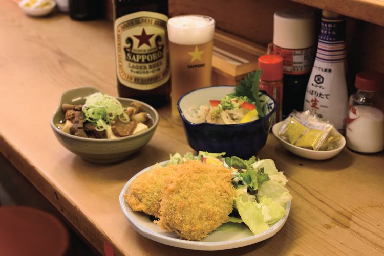 カレーコロッケ390円は、店主の母が手作り。煮込小の玉子入り590円、アジの南蛮漬け590円。赤星大瓶660円。