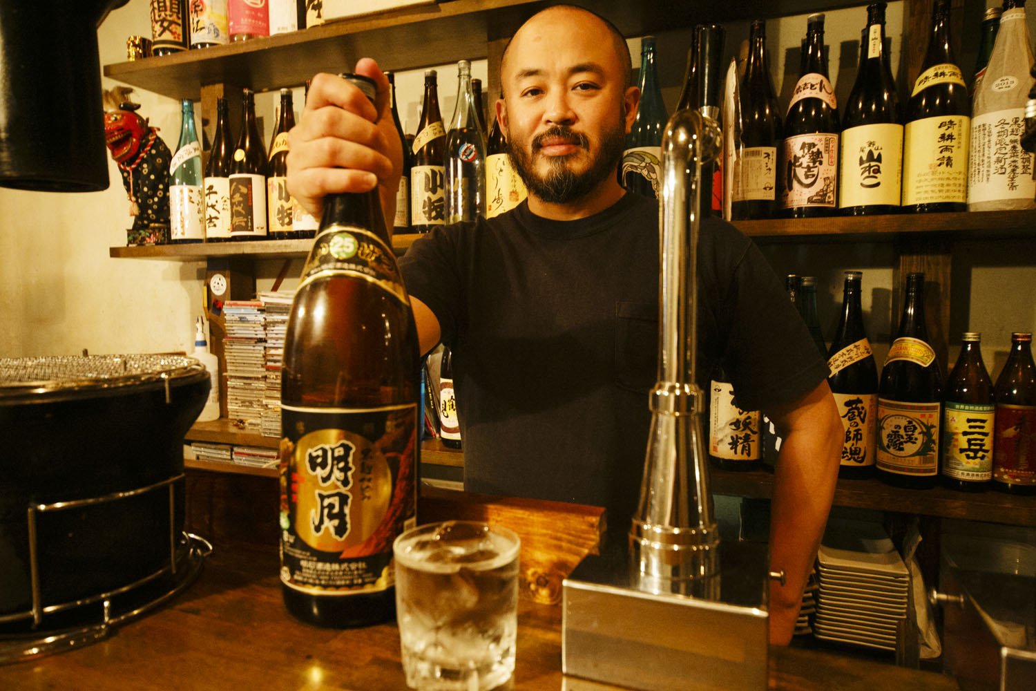店主の小野田さん。焼酎好き垂涎の「萬繕」から飲み口爽やかな夏焼酎まで各焼酎を税抜き500円で提供。「うちはBARじゃねえ。焼き肉屋よ!」。