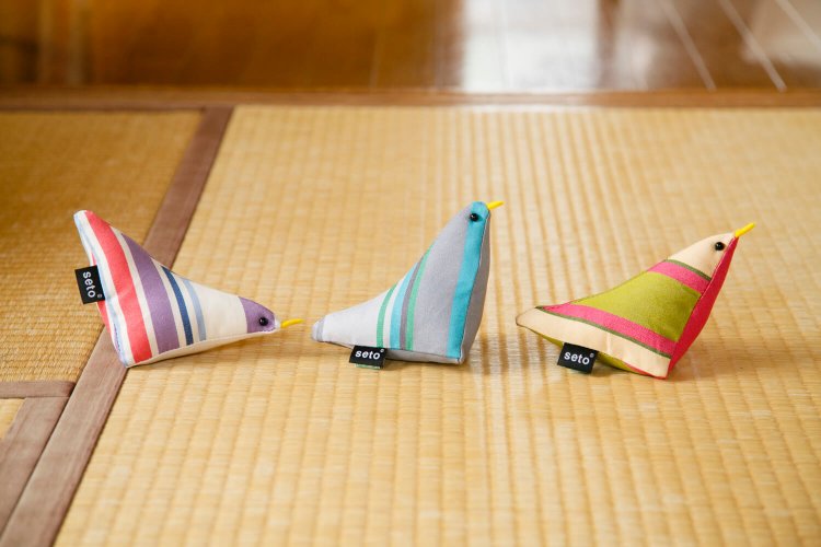 鳥がついばむ動作を取り入れた郷土玩具のようなベビー用ラトル、ペッキングバード2860円。自由学園生活工芸研究所オリジナルの色鮮やかなストライプ生地「プラネテ」を使ったシリーズ。