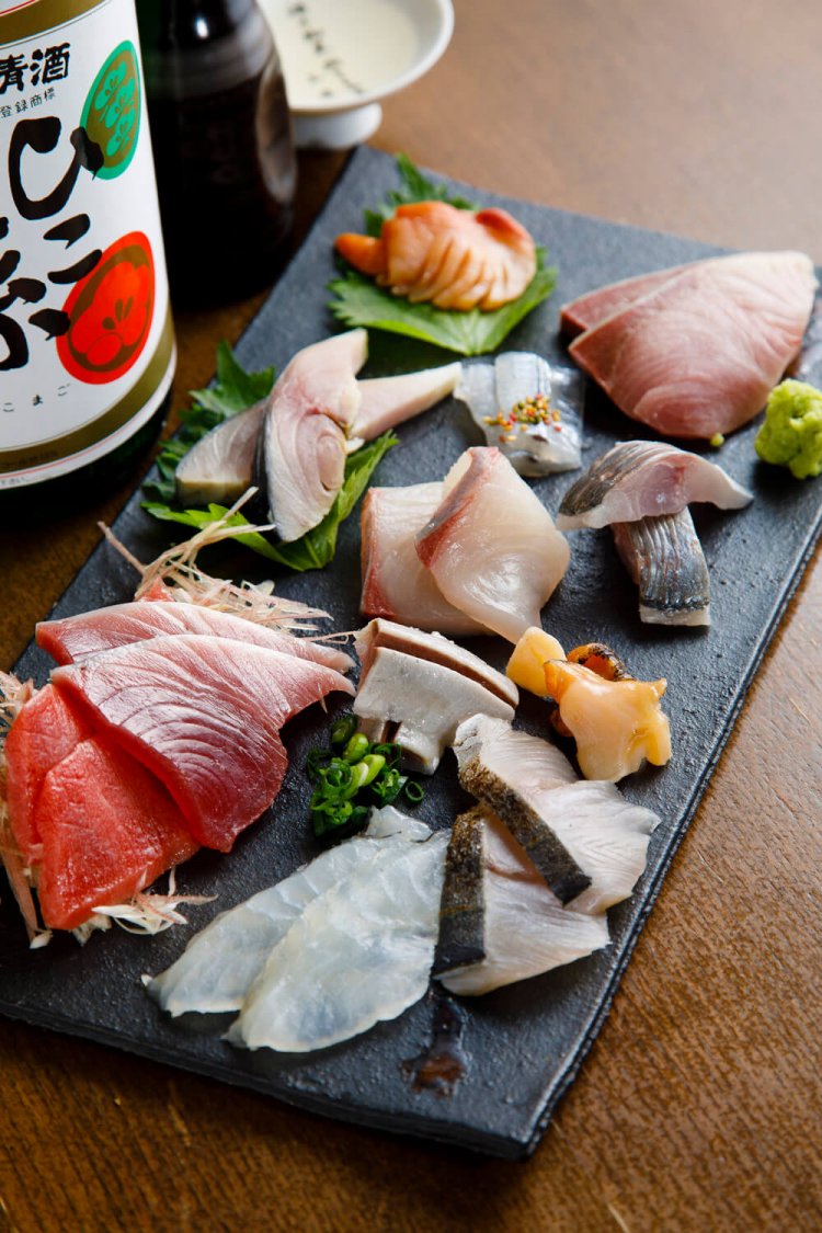 撮影当日は長崎の定置網のカツオなどが並んだお刺身盛り合せ1280円（写真は二人前）。ひこ孫徳利950円。