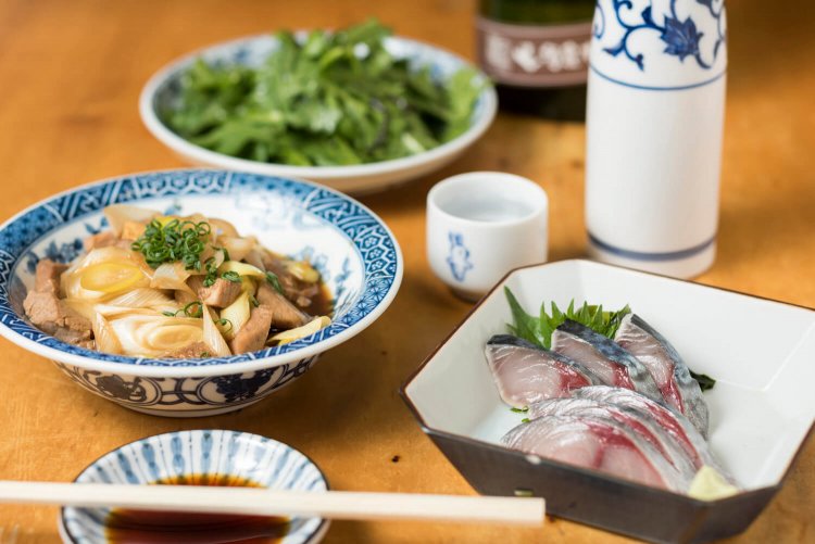  絶妙なシメ加減のシメサバ650円、ねぎま850円、春菊サラダ400円。右はお燗映えする奈良睡龍の純米古酒の徳利1300円。