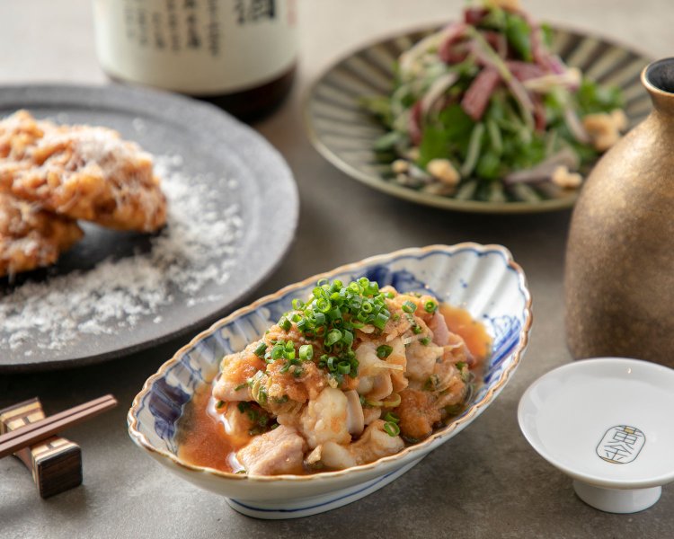 リードヴォーとトウモロコシのかき揚げ825円（左）など洋食出身の料理長が手掛ける牛モツ料理は絶品。日本酒グラス660円～。