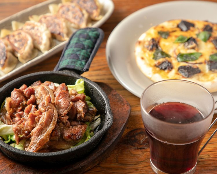 シナモン香るホットワイン650円、甘辛い豚肩ロースを鉄板で供するじゅうじゅう焼きLL1000円（左）。