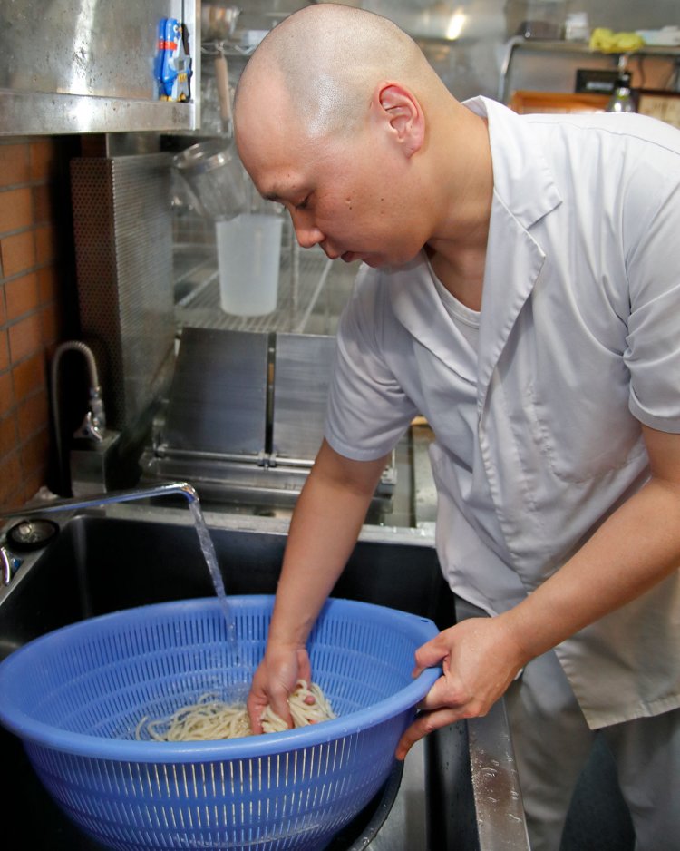 麺を冷水でしめる店主。ひやもりで頼むと弾くようなコシを楽しめる。