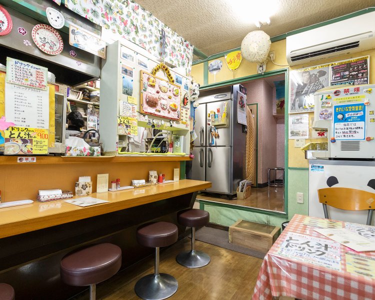 かわいらしい店内の所々に永ちゃんのポスターが。妻・美津子さん謹製のフェルトの縫いぐるみが品書き。