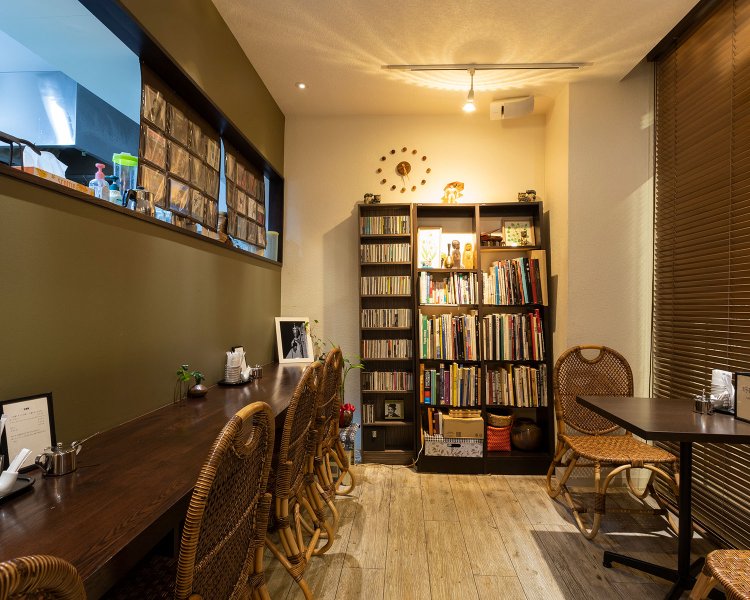 ゆったりした店内には書籍や民芸品が。新介さんの描いた絵画も飾られている。