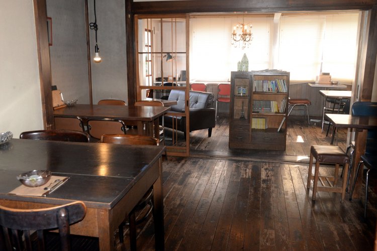 年代物の小ぶりなテーブルが並ぶ。席ごとに趣を変える演出が心憎い。