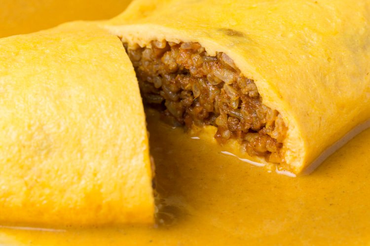 カレーソースで玉子包みのドライカレーをいただく新感覚オムライス。カレーにオムレツをのせた「オムカレー」ではない。