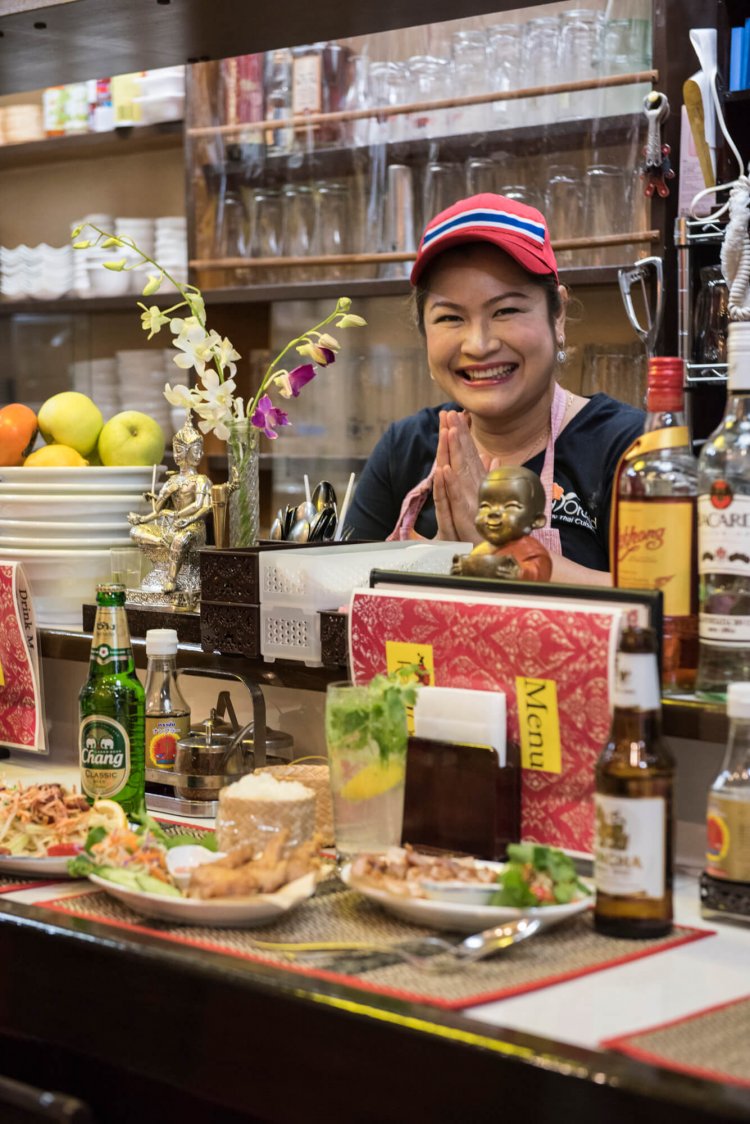 店主のシリワンさん。ガイ・トーッド・ナンプラー500円やパパイヤサラダ850円。メニュー多数。