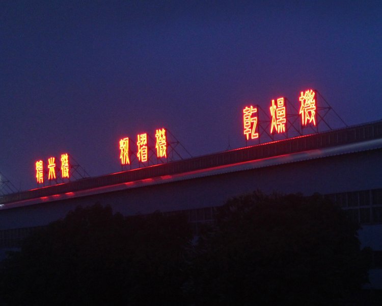 夜の新幹線にアピールする穀類調製機工場。楔形の書体がカッコいい。和賀川堤防から撮影。