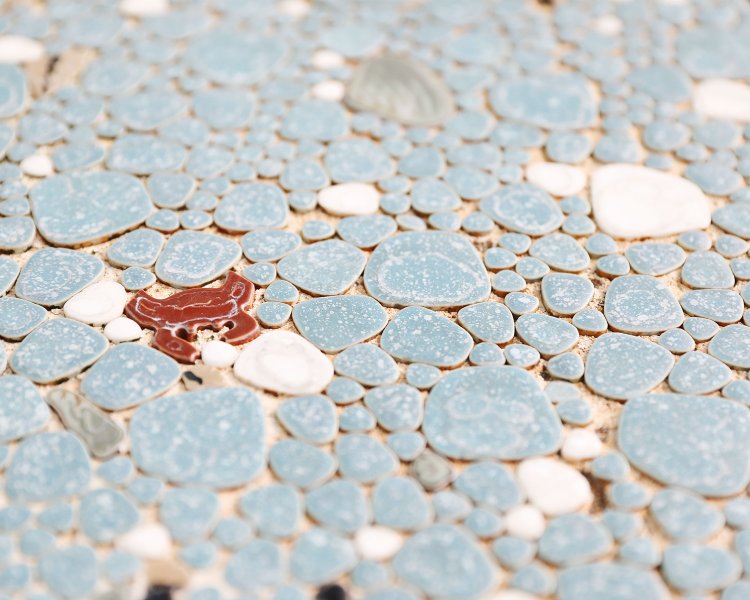 玉石タイルにカニや貝がちりばめられた愛らしい浴室の床。