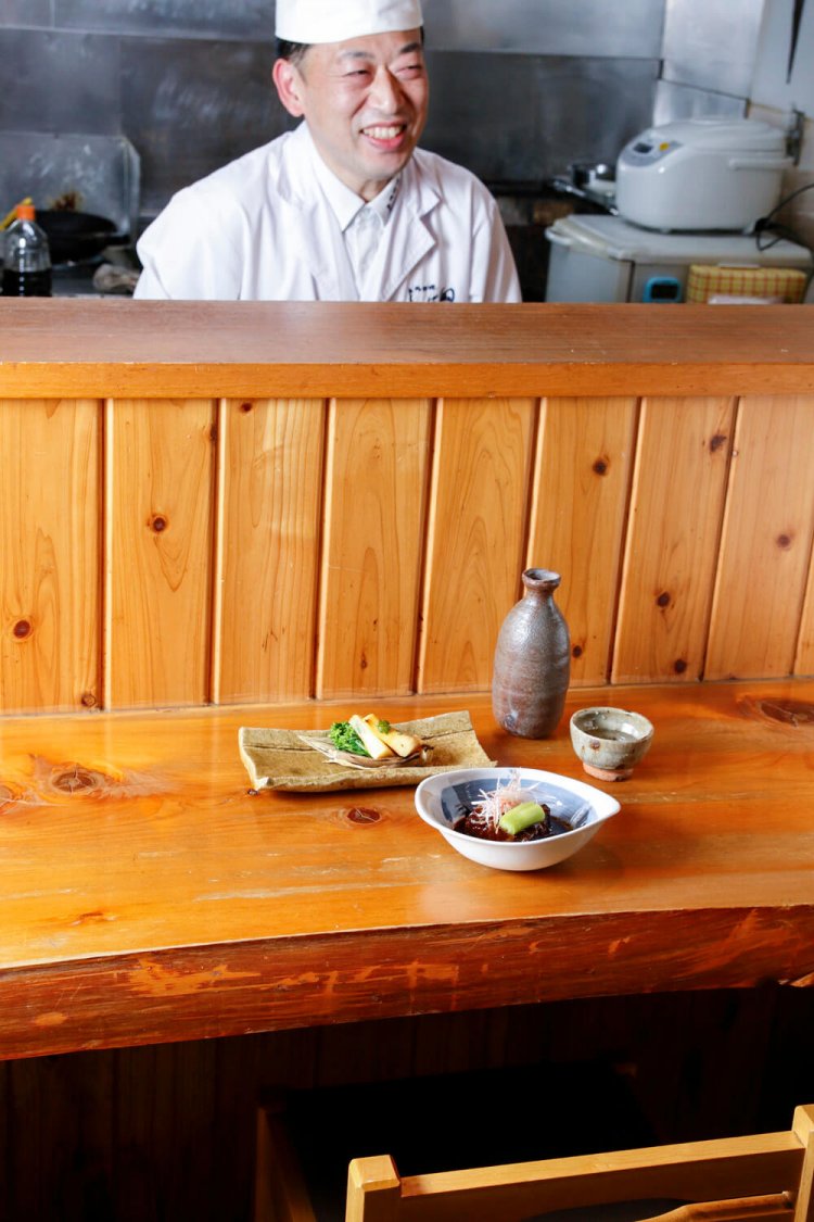 柴田さん。牛頬肉の煮込み（手前）1000円、早掘竹の子の炭火焼790円、日本酒は１合500円～。