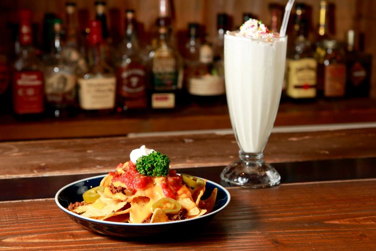 スパイスで漬けこんだひき肉をナチョチップスと食べる、ナチョグランデ700円。バニラシェイク600円。