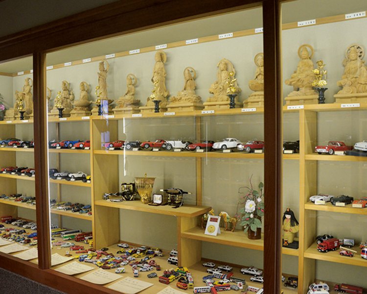 三十三観音とコラボ。ミニカーを並べ「祈交通安全」の文字を描く。