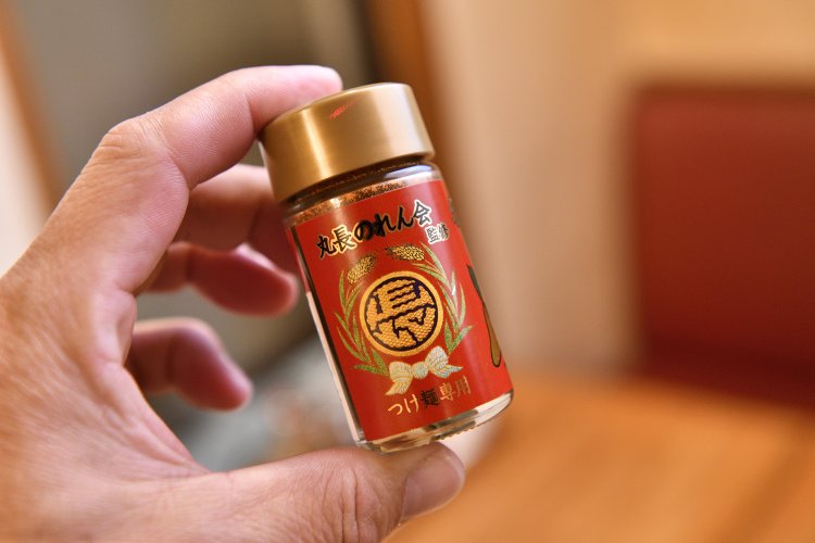 「丸長のれん会」の店舗限定で販売されているつけ麺用のオリジナル七味780円は、丸長のルーツである長野県にある七味唐辛子の有名店、『八幡屋礒五郎』とのコラボ商品だ。