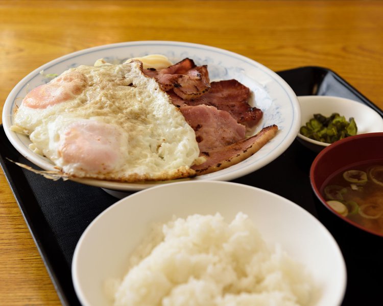 コショウたっぷりスパイシーなベーコンエッグ定食950円。目玉焼きの下にスパサラ。