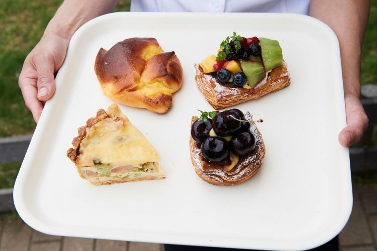 右上から時計回りに、キウイとマンゴーデニッシュ350円、アメリカンチェリーデニッシュ360円(季節限定)、キッシュロレーヌ390円、クリームパン200円。クリームパンは人気商品で常に焼きたてを用意。