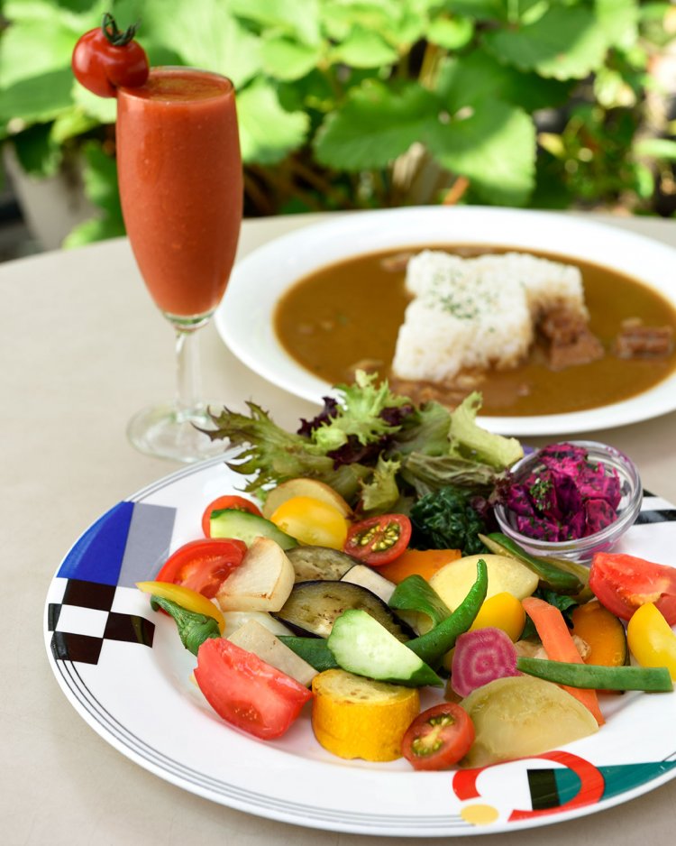 グリルした野菜や サラダが盛られた皿が付くいしい 農園カレー1200円、一平トマトのトマトジュース700円(季節限定)。