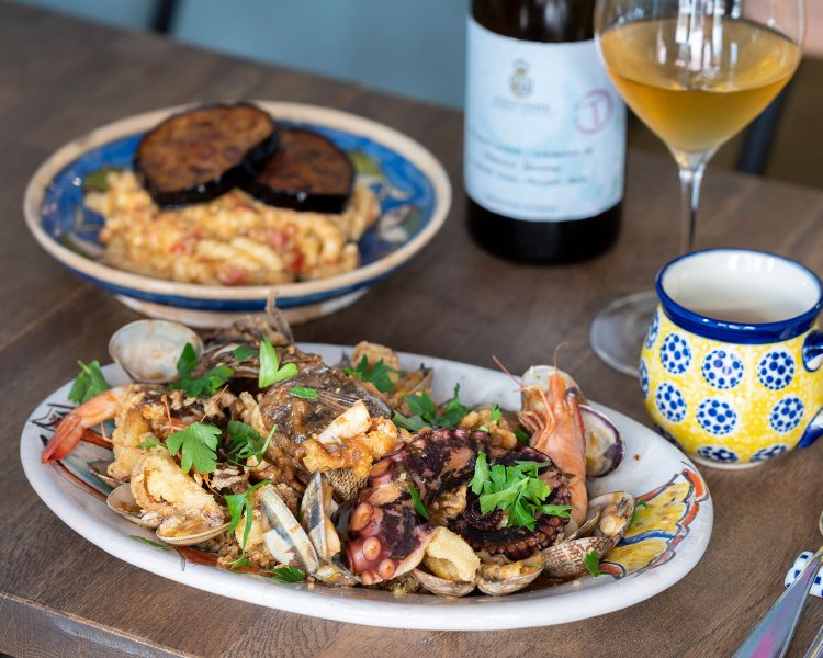 シチリア仕込みのお魚のクスクス2680円（税抜、魚種により変動あり）、揚げナスが鎮座するアッギアスパゲッティ1600円(税抜)。ボトルワイン3600円～(税抜)。