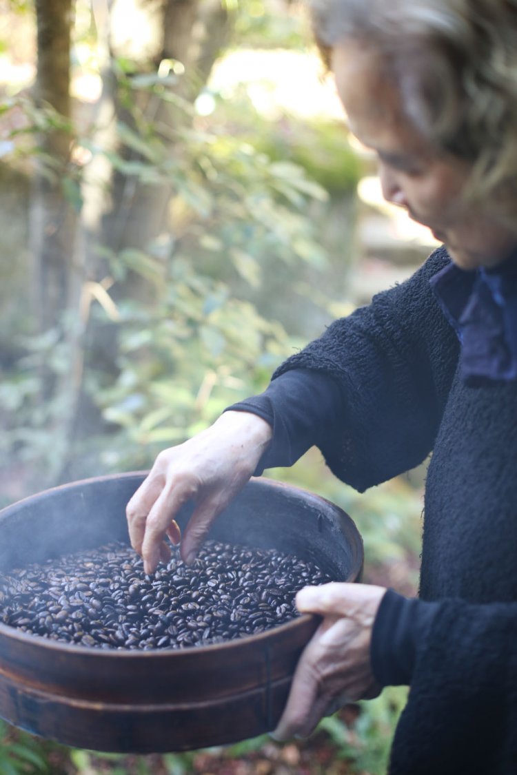 コーヒー豆は、骨董品のような焙煎機で煎る。焦げた豆を撥（は）ねる内田さん。「庭の土に還してあげるのよ」。