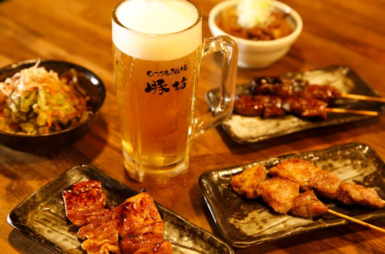 手前から反時計回りにテッポウ、腕、レバ2 本各240 円、もつ煮込み280円ほか。生中470円。