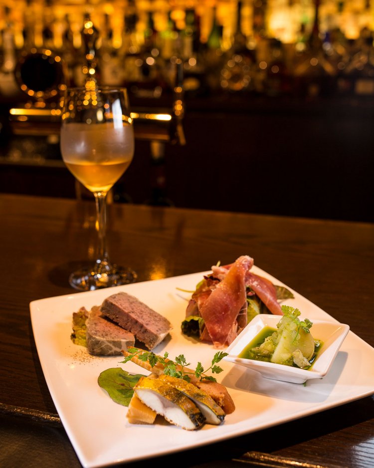 パテ・ド・カンパーニュ、スモークなど、自家製つまみのオードブル盛り合わせ1650円。氷をひとかけら入れワイングラスで供するのは、竹鶴タクトスタイル 990円。