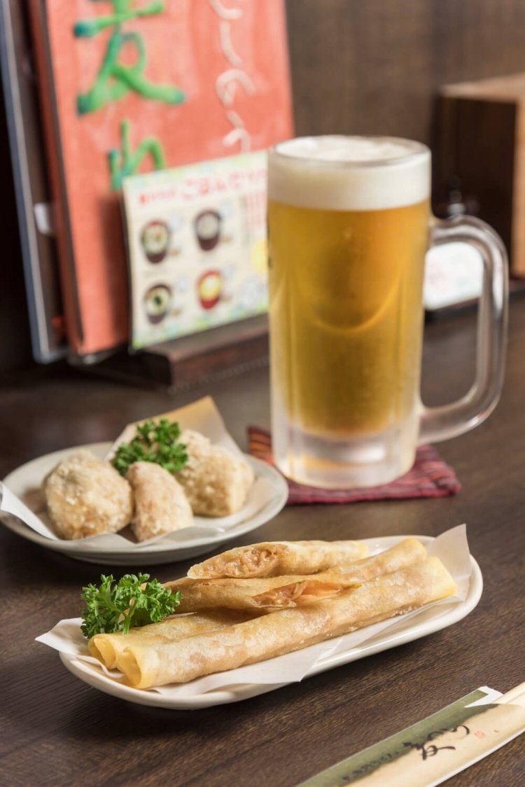 カリ揚げもんじゃ1本100円はソース味とカレー味から選べる。揚げ里芋400円、生ビール500円。
